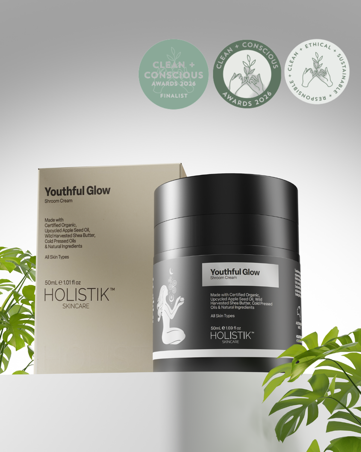 Holistik Skincare 'Youthful Glow Shroom Cream with Clean & Conscious Finalist award and greenery on a light gray background